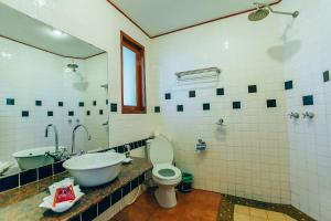 a bathroom with a sink and a toilet and a tub at Krabi Sands Resort in Klong Muang Beach