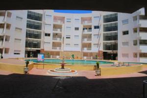 a large building with a fountain in front of a building at Soleil & Piscine BOUZNIKA in Bouznika