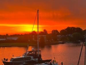 a boat docked in a marina at sunset at Näher am Wasser kann man nicht wohnen! in Arnemuiden
