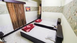 a bedroom with two beds and a window at HOTEL HERITAGE in Chittagong