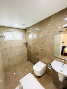 La salle de bains est pourvue de toilettes et d'un lavabo. dans l'établissement The Oval House - Approved by Kerala Tourism, à Cochin