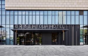 um edifício com uma placa para um hotel em Atour Hotel Taixing Municipal Government Drum Tower Xintiandi em Taizhou