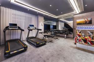 a gym with treadmills and exercise equipment in a room at Atour Hotel Nantong Jinsha in Nantong