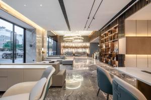 a lobby with chairs and a bar in a building at Atour Hotel Jiaojiang Taizhou in Taizhou