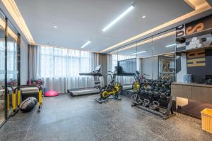 a gym with bikes and exercise equipment in a room at Atour Hotel Jiaojiang Taizhou in Taizhou