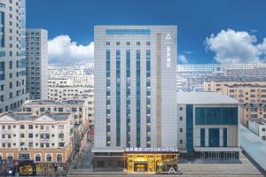 a large tall building in a city with buildings at Atour Hotel Bohai International Plaza Binzhou in Binzhou