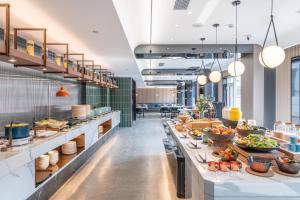 a buffet line in a restaurant with plates of food at Atour Hotel Bohai International Plaza Binzhou in Binzhou