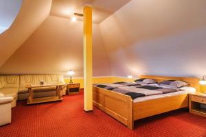 Penzion Lhotka في أوسترافا: غرفة نوم بسرير واريكة