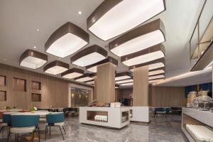 a lobby with tables and chairs and lights at Atour Hotel Zezhou Road Jincheng in Jincheng