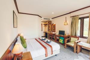 a bedroom with a bed and a desk and a television at Krabi Sands Resort in Klong Muang Beach