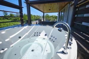 a jacuzzi tub on the deck of a house at Beach Side Secret in Ginoza