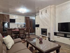 sala de estar con sofá y mesa con chimenea en Luxe Apartment Grand Monastery in Pamporovo, en Pamporovo