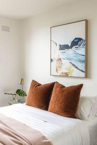 a bedroom with a bed with a picture on the wall at Iconic Mid-century modern, waterfront apartment in Geelong