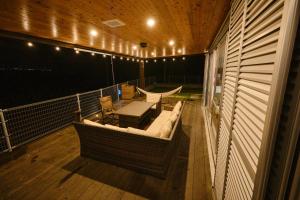 a balcony with a hammock and a table and chairs at Beach Side Secret in Ginoza
