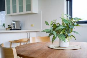 a wooden table with a potted plant on top of it at Iconic Mid-century modern, waterfront apartment in Geelong