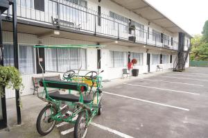 una bicicleta verde estacionada fuera de un edificio en Forgotten World Motel en Taumarunui