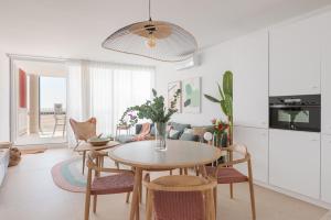 eine Küche und ein Esszimmer mit einem Tisch und Stühlen in der Unterkunft Marsalada - Ground floor front line beach apartment in Playa de Mar