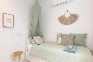 Playa de MarにあるMarsalada - Ground floor front line beach apartmentの白いベッドと窓のある小さな寝室