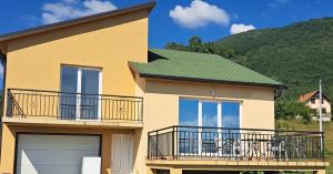 a house with a balcony and a green roof at Topla porodicna kuca in Berane