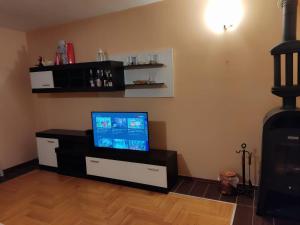 a living room with a flat screen tv on a cabinet at Topla porodicna kuca in Berane