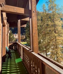 a wooden porch with a green staircase on a house at Hotel Simader in Bad Gastein