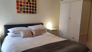 a bedroom with a bed with two pillows and a cabinet at Spacious Central London 2 Bedroom Mansion Block Apartment in London