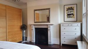 a bedroom with a fireplace and a mirror on the wall at Spacious Central London 2 Bedroom Mansion Block Apartment in London