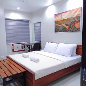 Grace & RB Hotel في كاليبو: غرفة نوم بسرير كبير مع شراشف بيضاء