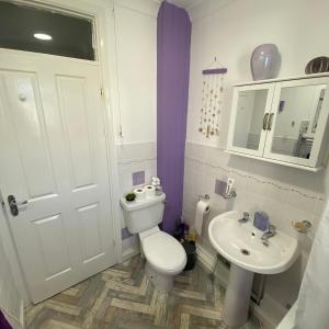 a white bathroom with a toilet and a sink at Agapanthus Bed & Breakfast - Fraddam in Hayle