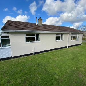 a white house with a grass yard at Agapanthus Bed & Breakfast - Fraddam in Hayle