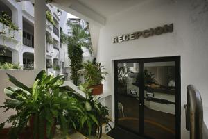 un edificio de oficinas con plantas delante de una puerta en One Beach Street Puerto Vallarta, en Puerto Vallarta