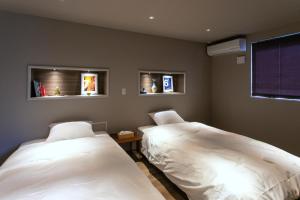 佐世保的住宿－VILLA Sasebo Stad #SS1，一间卧室设有两张床和两个窗户。