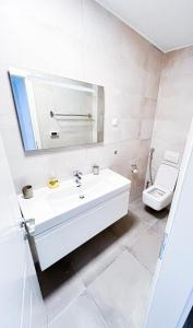 een witte badkamer met een wastafel en een toilet bij The Place Apartments in Srima