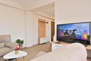 uma sala de estar com uma grande televisão de ecrã plano em Durau Residence em Piatra Neamţ