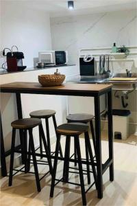 a kitchen with a counter with four bar stools at Villa Cardui. Casa de diseño con magníficas vistas in Madrid