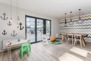 ein Wohnzimmer mit Tisch und ein Esszimmer in der Unterkunft KOŁOBrzegu Apartamenty by Jantar Apartamenty Kołobrzeg in Kołobrzeg