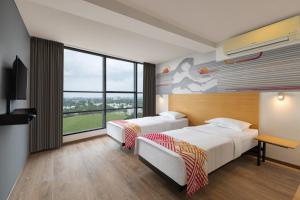 a hotel room with two beds and a large window at Ginger Ahmedabad RTO Circle in Ahmedabad