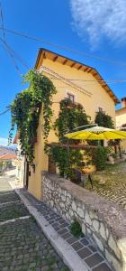 a yellow building with an umbrella and a bench at Scaccia pensieri in Cerchio