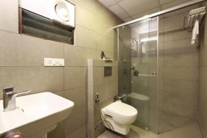 een badkamer met een toilet, een wastafel en een douche bij Ginger Ahmedabad RTO Circle in Ahmedabad