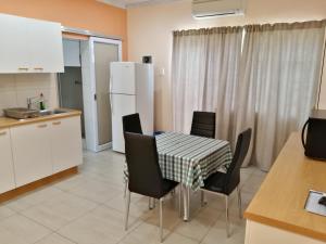 a kitchen and dining room with a table and chairs at Capbon Guesthouse in Windhoek