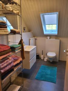 a bathroom with a sink and a toilet and a window at Ferienwohnung Deichblick in Gerhardshofen