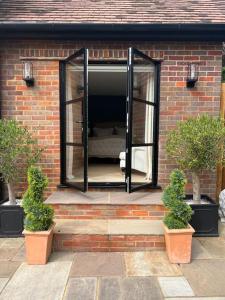 a window on a brick building with two potted plants at Boutique style self contained annexe with garden in Mursley