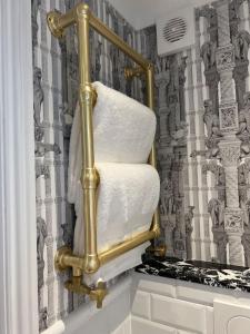 un toallero de oro en un baño con silla en Boutique style self contained annexe with garden, en Mursley