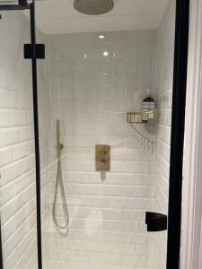 a bathroom with a shower with white tiles at Boutique style self contained annexe with garden in Mursley