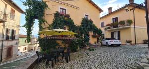 a table with an umbrella on a street at Scaccia pensieri in Cerchio