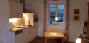 a kitchen with a table and a sink and a window at Ferienwohnung Koch in Odenthal