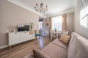 a living room with a couch and a tv at Charming Latvian classic style apartment in Rīga