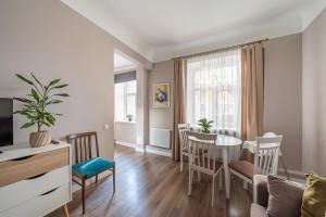 a living room with a table and a dining room at Charming Latvian classic style apartment in Rīga