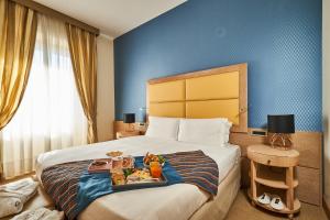 una camera d'albergo con un letto e un vassoio di cibo sopra di Hotel Astoria a Biella