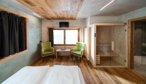 - une chambre avec deux chaises, un lit et une fenêtre dans l'établissement Hotel Larice, à Livigno